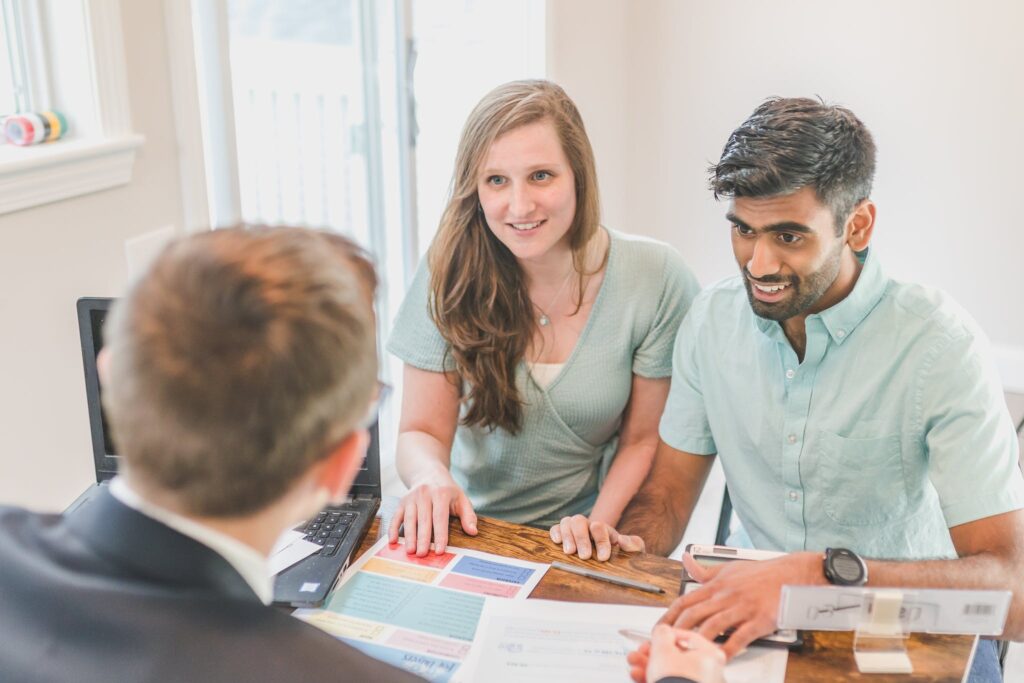 A Smiling Couple Talking to the Agent